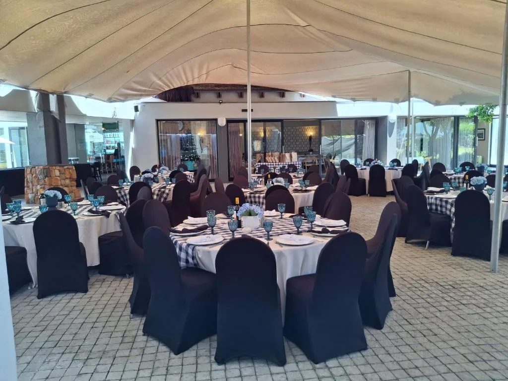 Covered outdoor terrace with round dining tables set for event