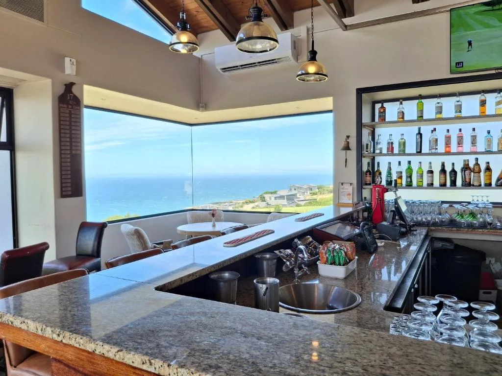 Modern bar counter with ocean view through floor-to-ceiling windows