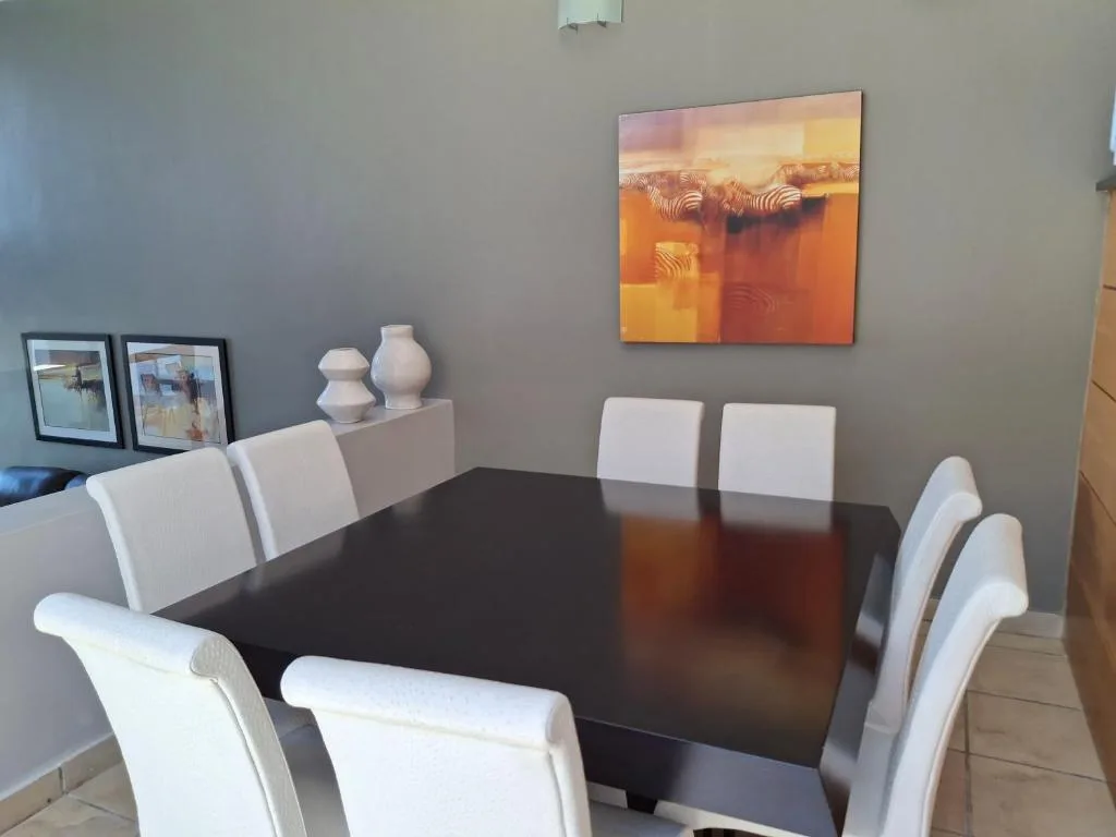 Modern dining room with black table and white upholstered chairs