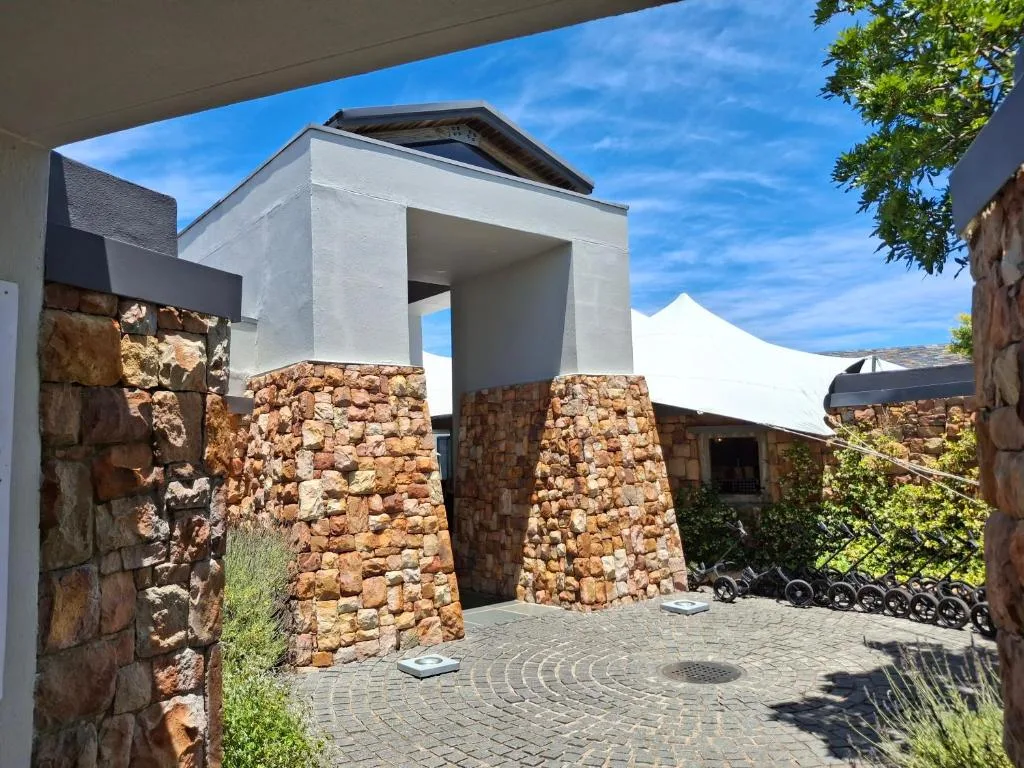 Modern white building with stone pillars and paved courtyard entrance