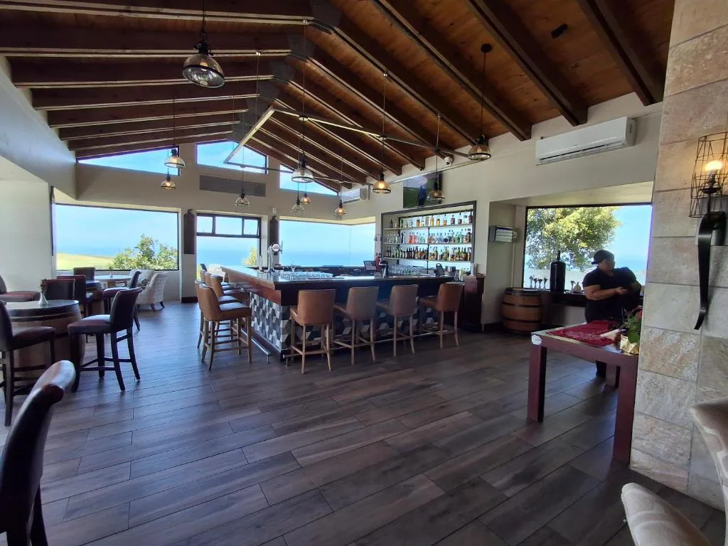 Modern lounge with bar counter, ocean views, exposed beam ceiling