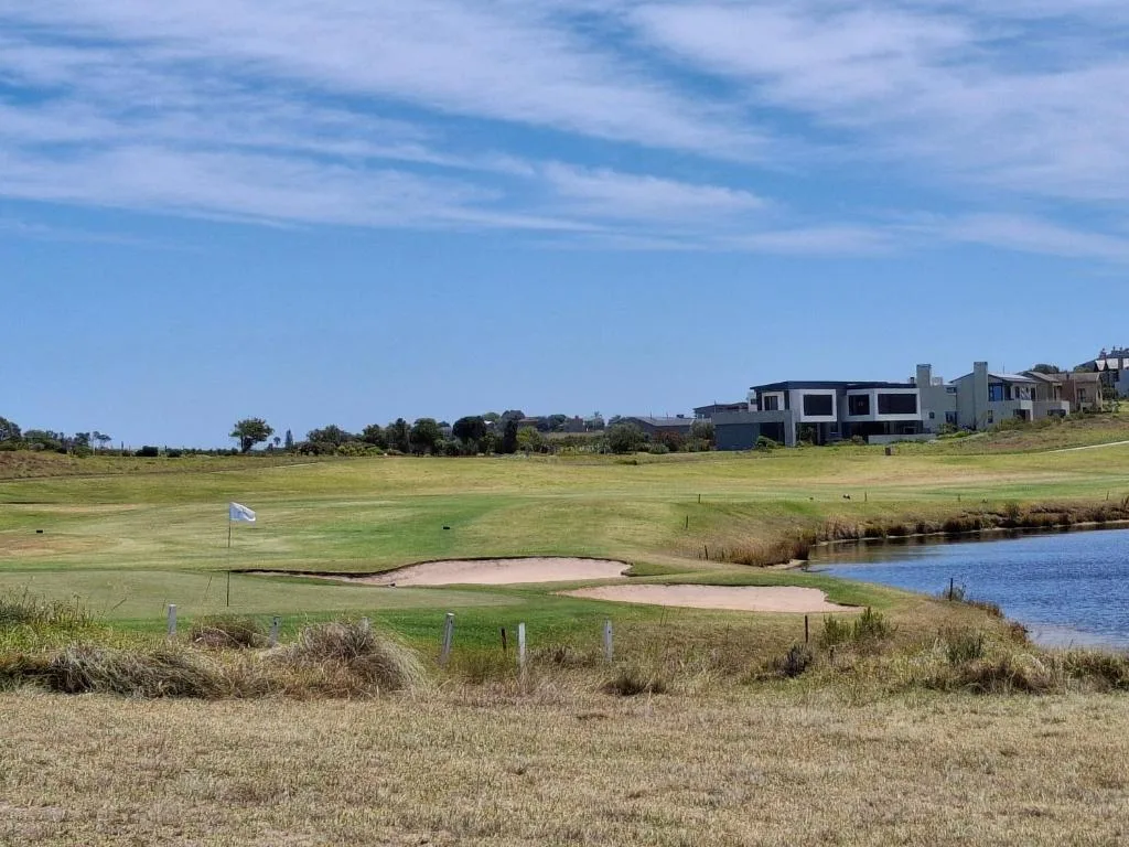 Scenic lagoon and golf course vista with modern homes in distance