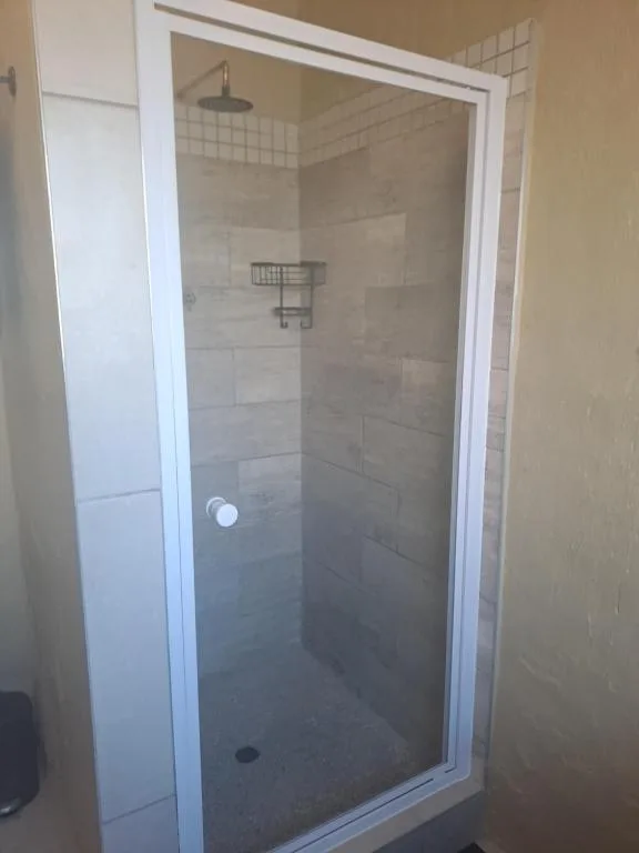 Modern walk-in shower with rainfall showerhead and tiled walls