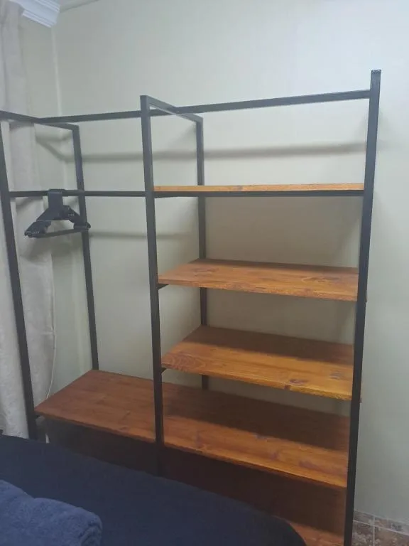 Industrial-style loft bed with metal frame and wooden shelving storage