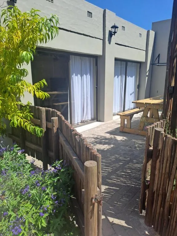 Wooden deck with picnic table and garden access to apartment