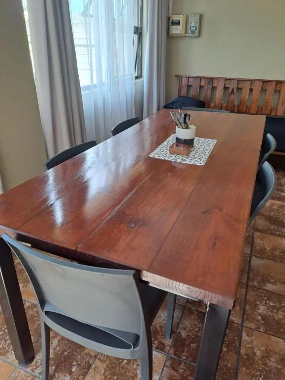 Wooden dining table with chairs and window view in apartment