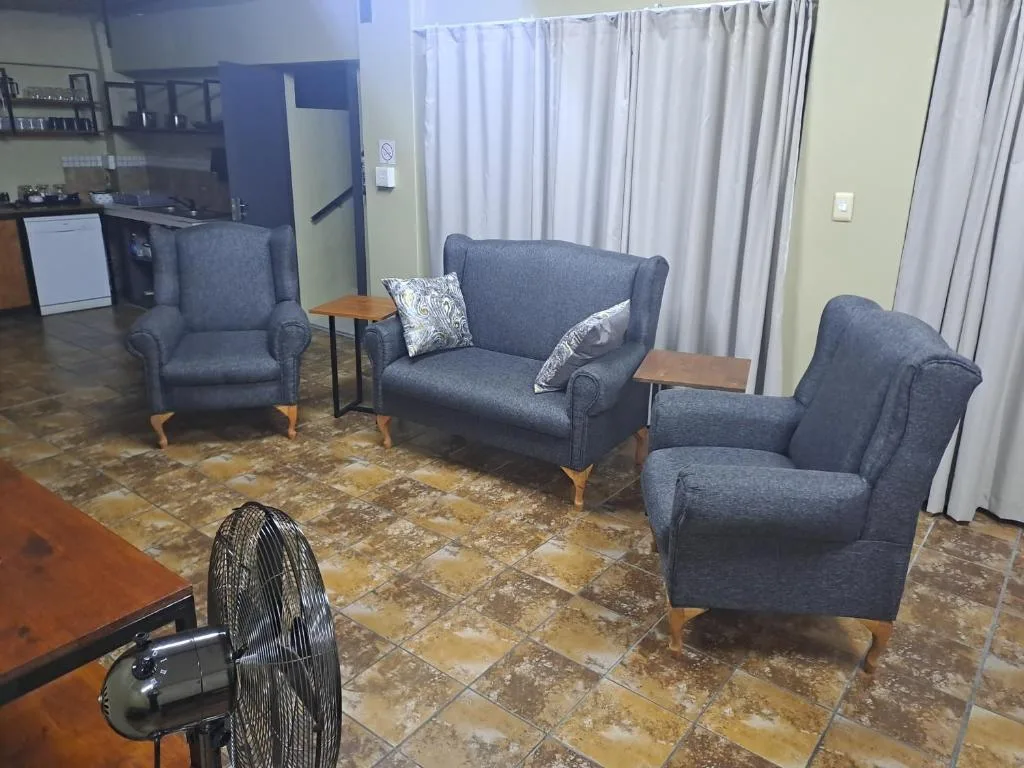 Living room with blue upholstered sofa and matching armchairs, wooden side tables