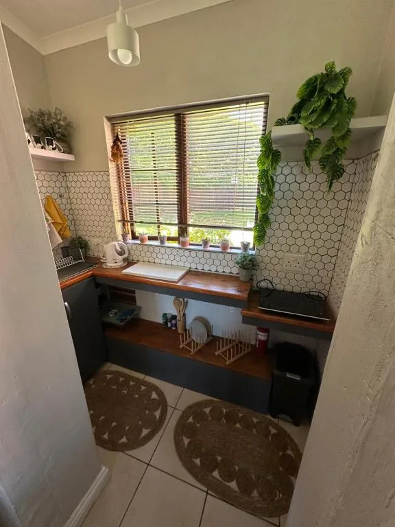 Modern bathroom with hexagonal tile backsplash, wooden vanity, and natural light from window