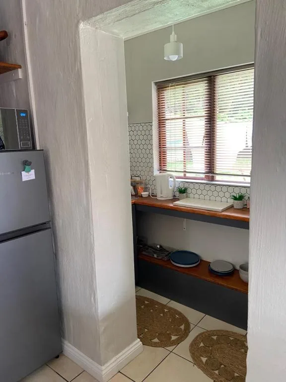 Compact kitchen with refrigerator, window, hexagonal tile backsplash, wooden countertop
