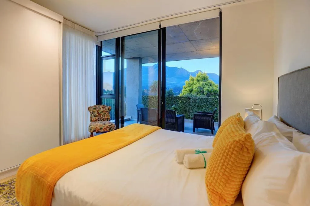 Bedroom with mountain view through sliding glass doors and yellow accents