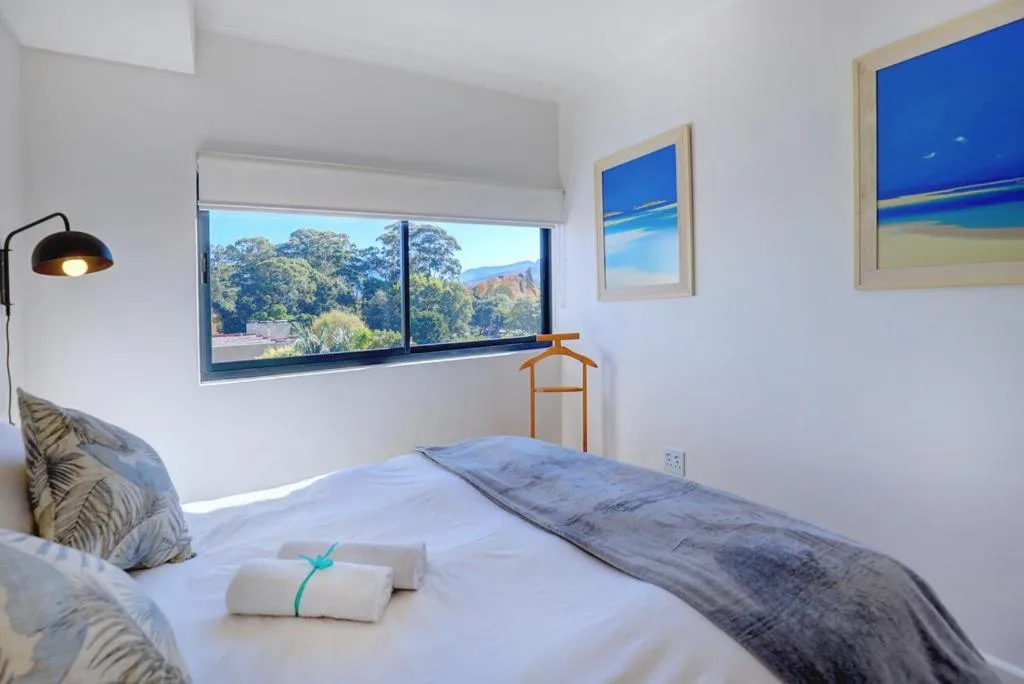 Bright bedroom with large window overlooking mountains and trees
