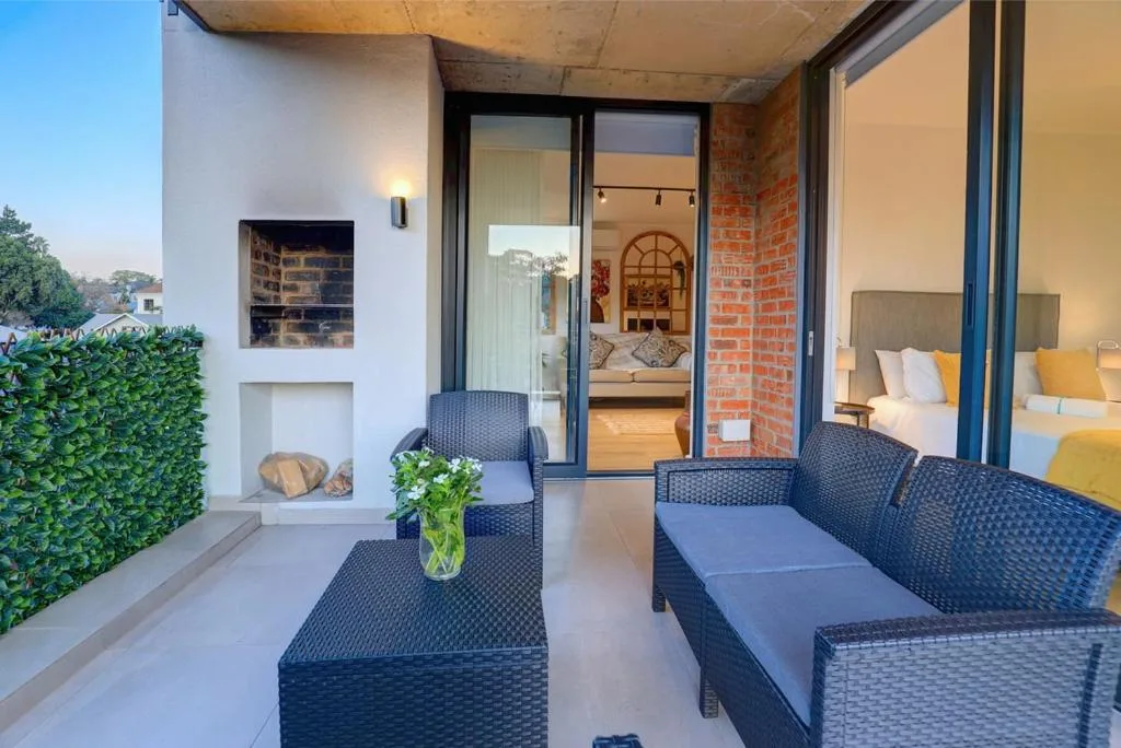 Modern patio with wicker furniture overlooking bedroom and fireplace
