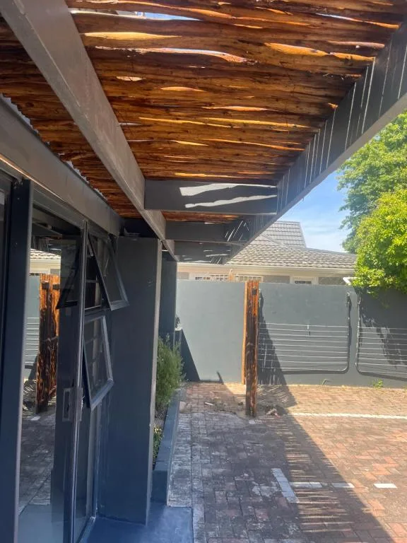 Covered patio with wooden beams and brick flooring, contemporary design