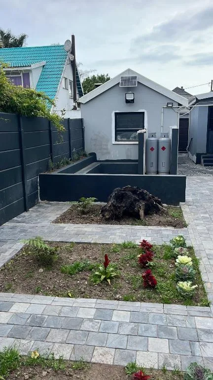 Modern cottage with turquoise roof and landscaped garden pathway