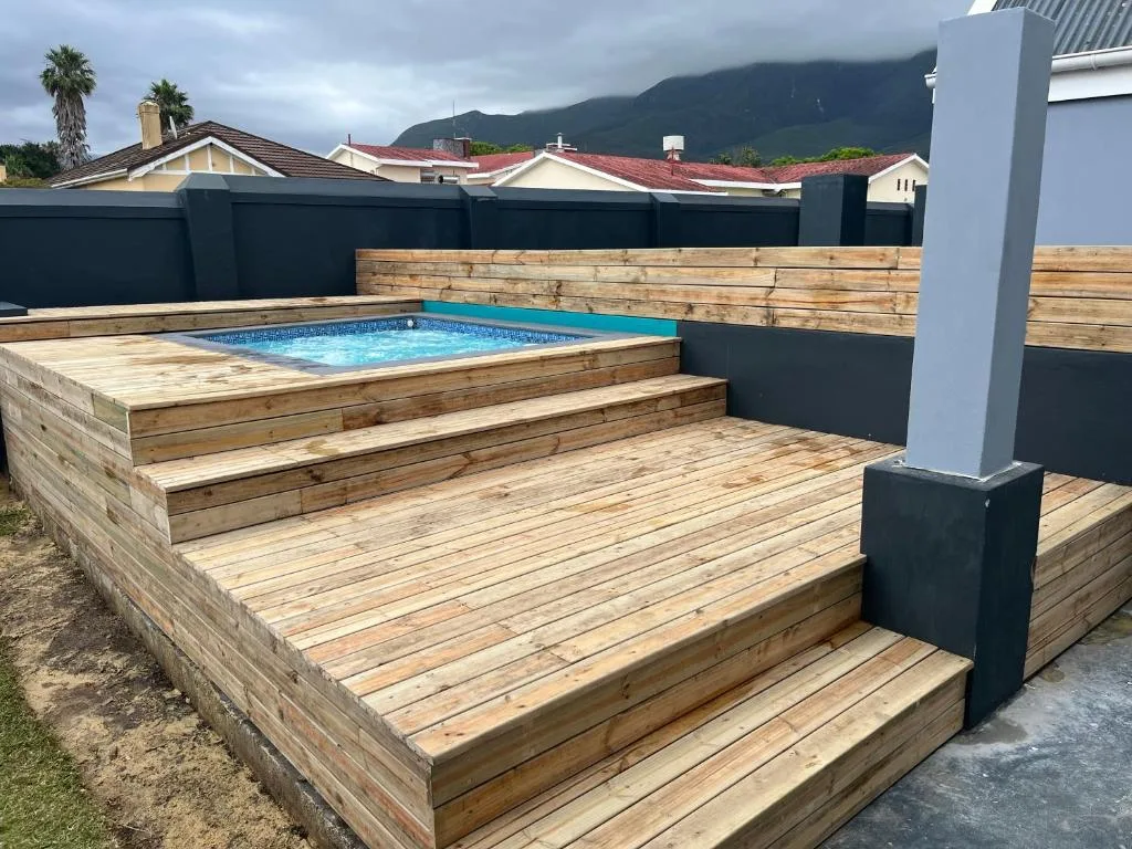 Above-ground swimming pool with wooden deck and mountain views