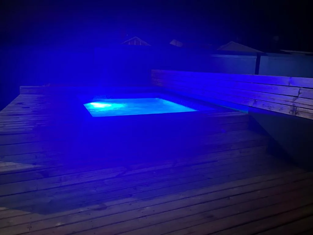 Illuminated swimming pool at night with bright blue LED lighting