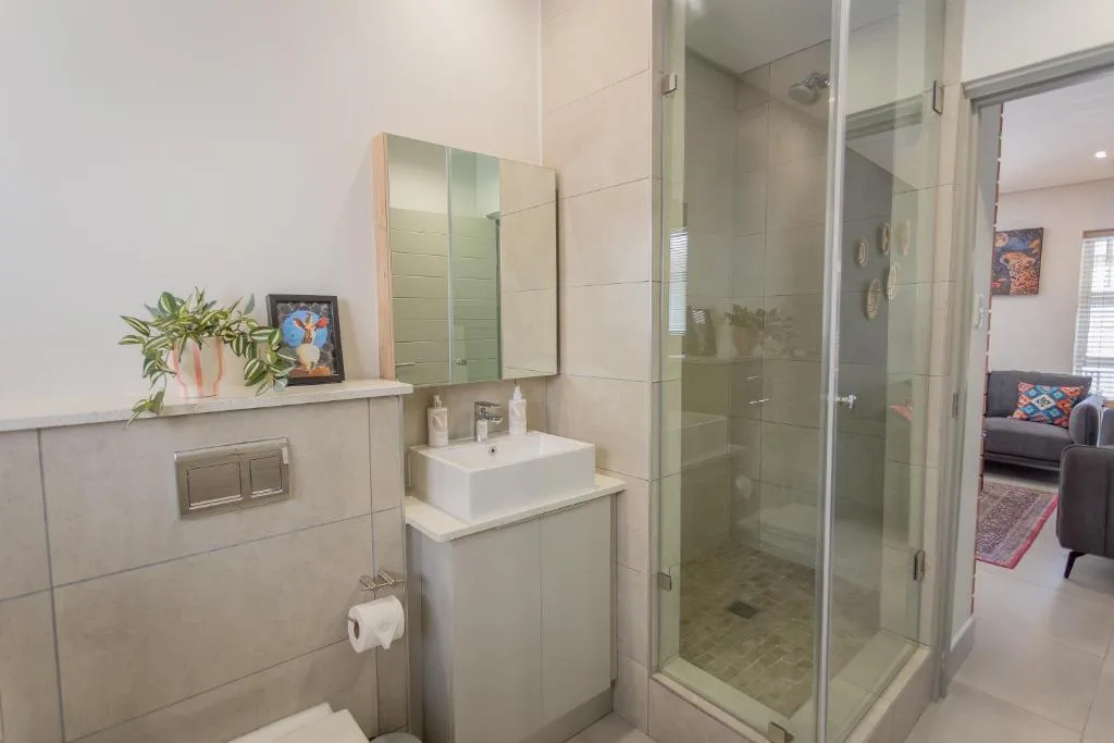 Modern bathroom with vanity sink, mirror cabinet, and glass shower enclosure