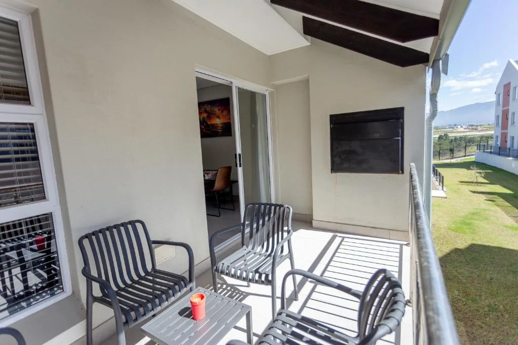 Covered balcony with comfortable seating and view to landscaped grounds