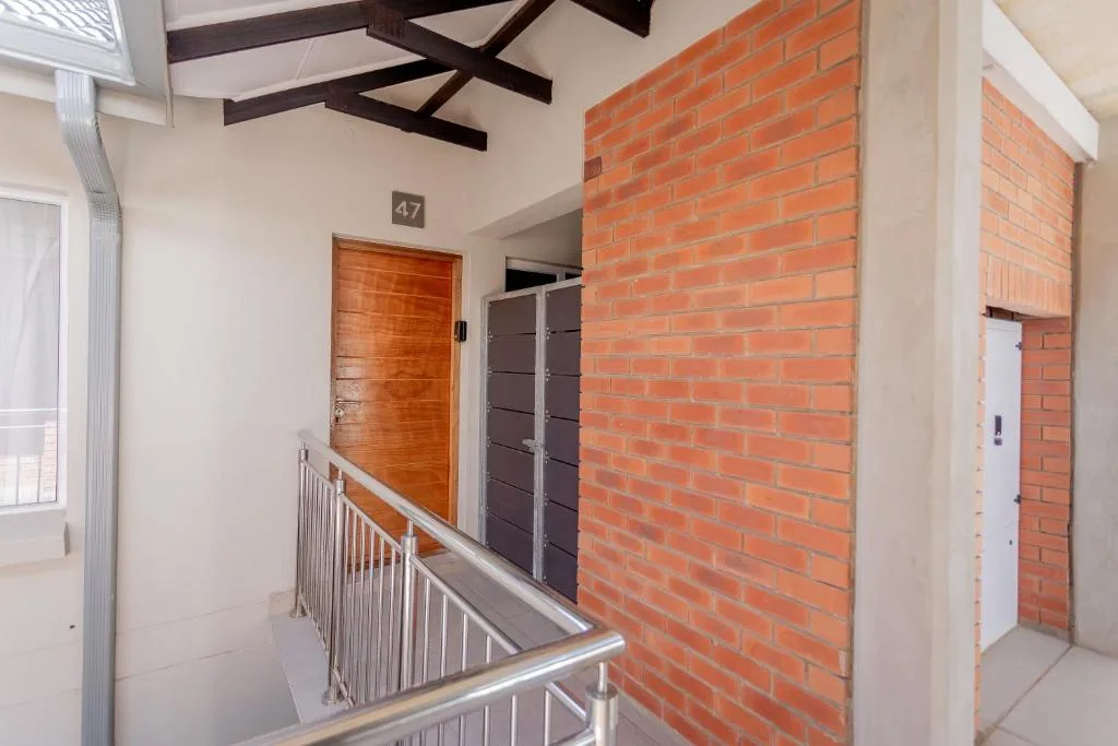 Interior hallway with exposed brick wall and staircase railing