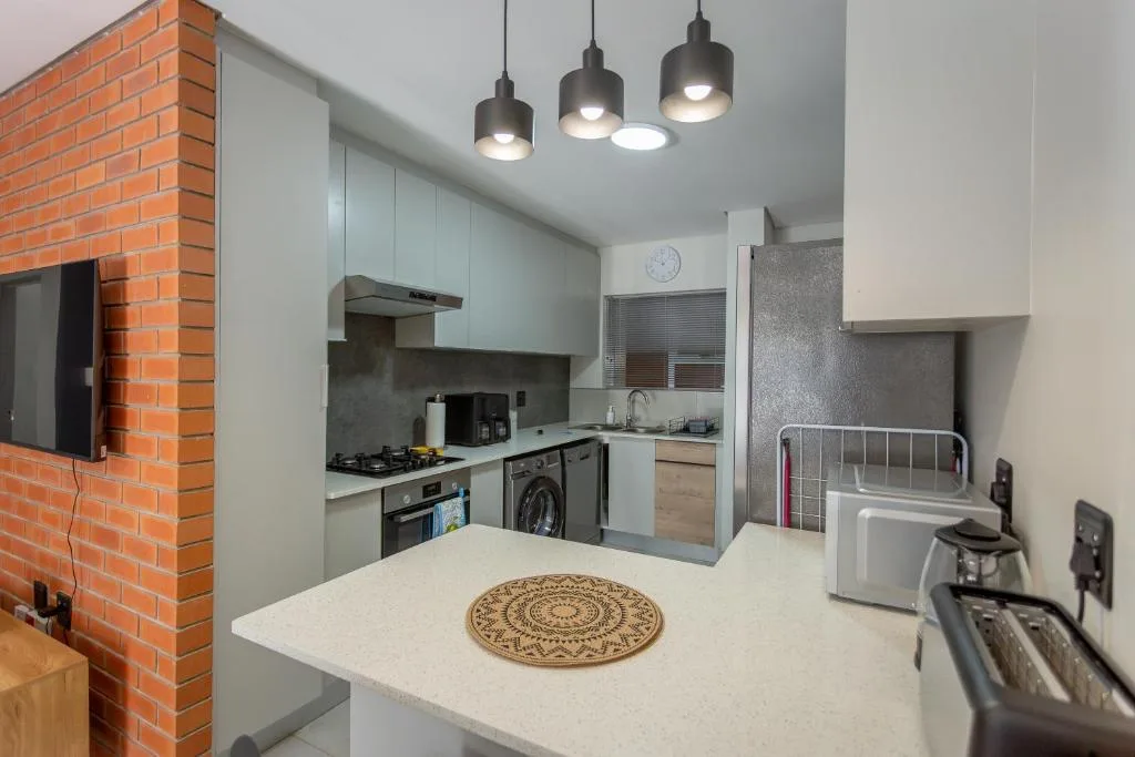 Modern kitchen with gas stove, white cabinetry, and pendant lighting overhead