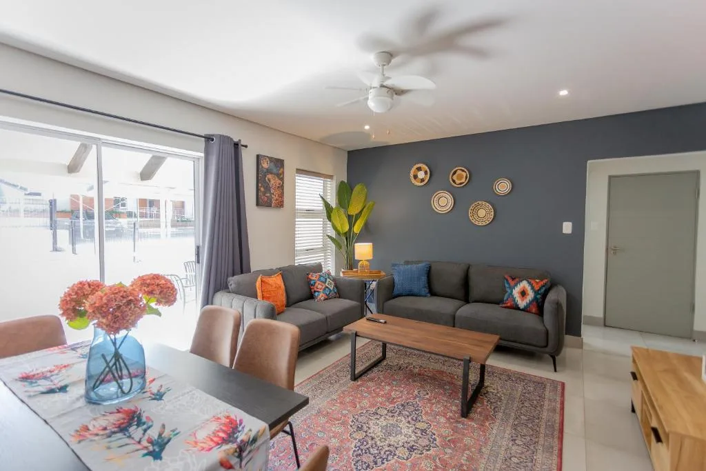 Contemporary living room with gray sofa, decorative wall plates, and garden views