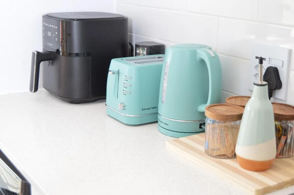 Kitchen counter with modern appliances and turquoise kettle and toaster