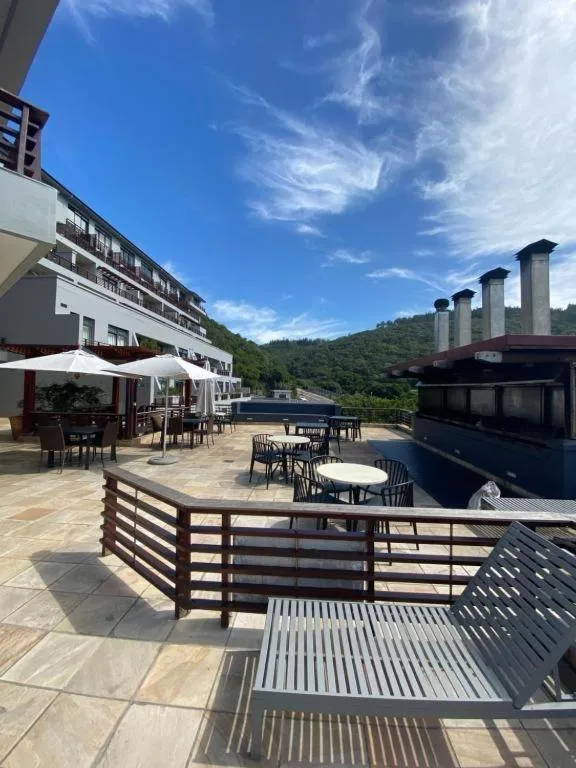 Expansive outdoor deck with dining areas, umbrellas, and mountain views