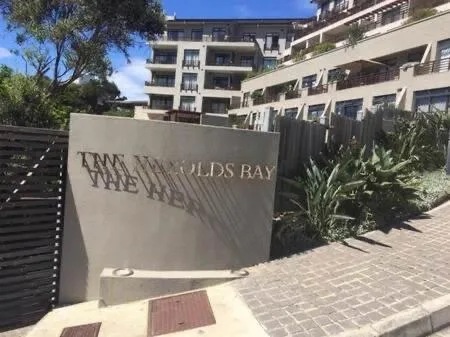 Modern apartment building entrance with branded signage and paved courtyard