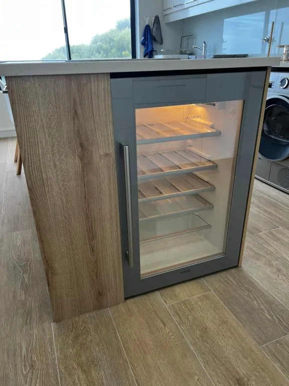 Modern built-in wine cooler with glass door in contemporary kitchen