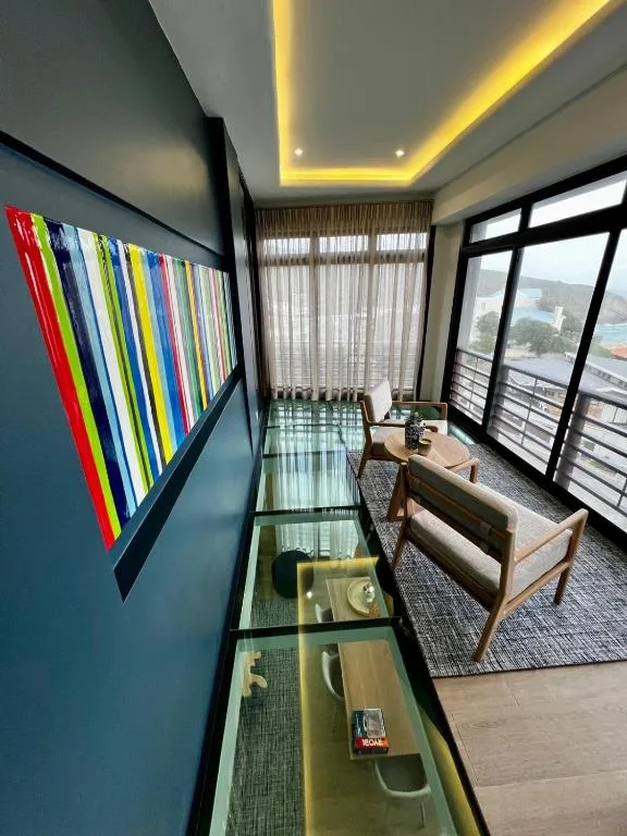 Modern lounge with colorful artwork, contemporary seating, and mountain views through windows