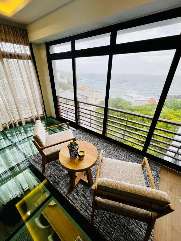 Oceanfront vista from penthouse lounge with seating and panoramic windows