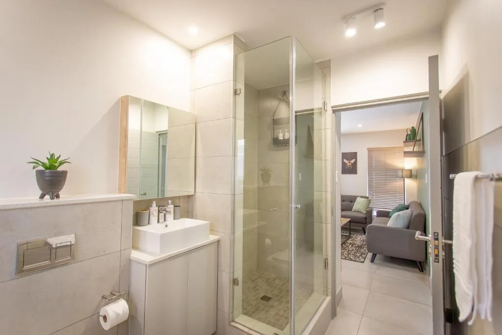 Modern bathroom with frameless shower enclosure and white vanity