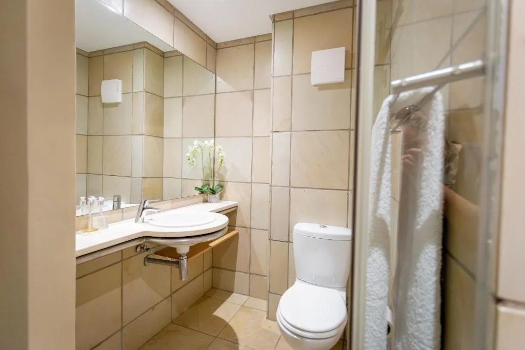 Modern bathroom with vanity sink, toilet, and glass shower enclosure