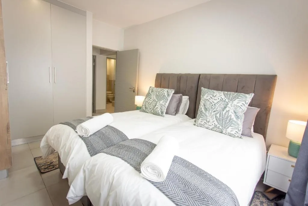 Modern bedroom with upholstered gray headboard and white bedding