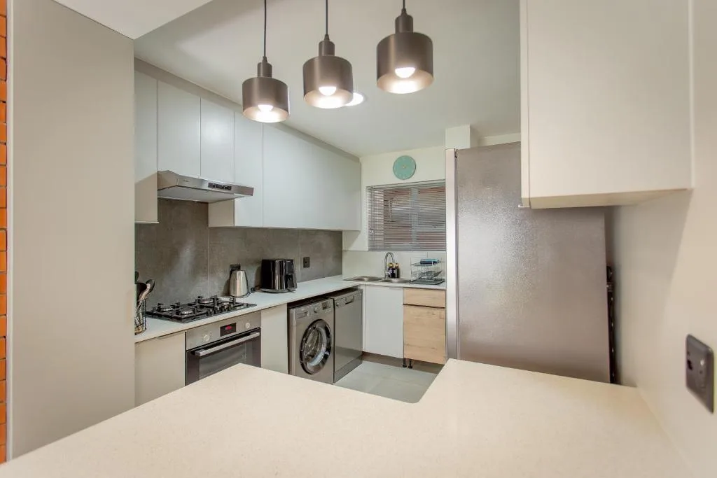 Modern kitchen with white cabinetry, gas stove, and stainless steel appliances