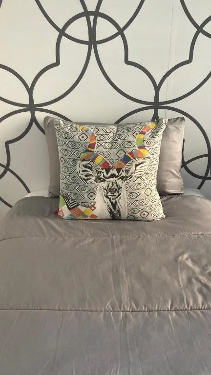 Bed with decorative pillows and geometric patterned headboard