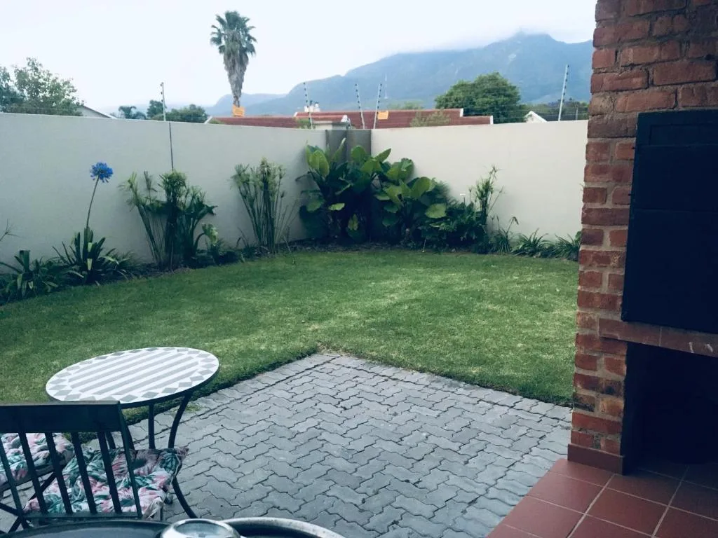 Paved patio area with garden seating and mountain views beyond