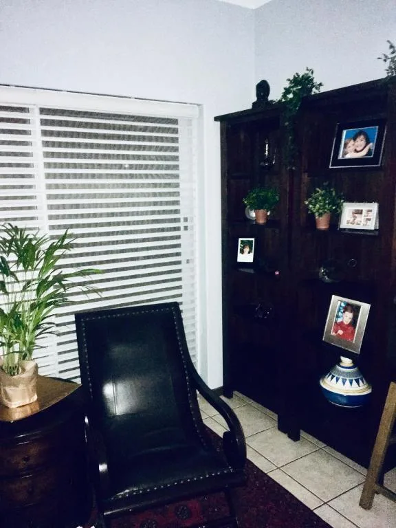 Black shelving unit with framed photos, plants, and decorative items