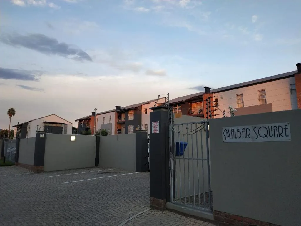 Modern apartment complex entrance with gated entry at dusk