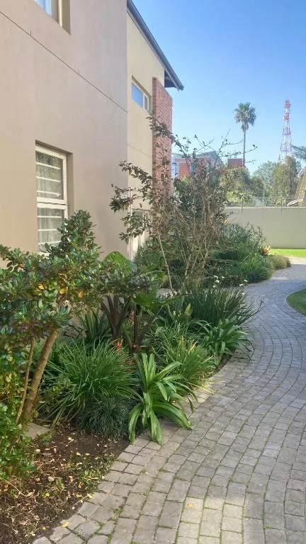 Modern apartment exterior with landscaped garden and paved pathway