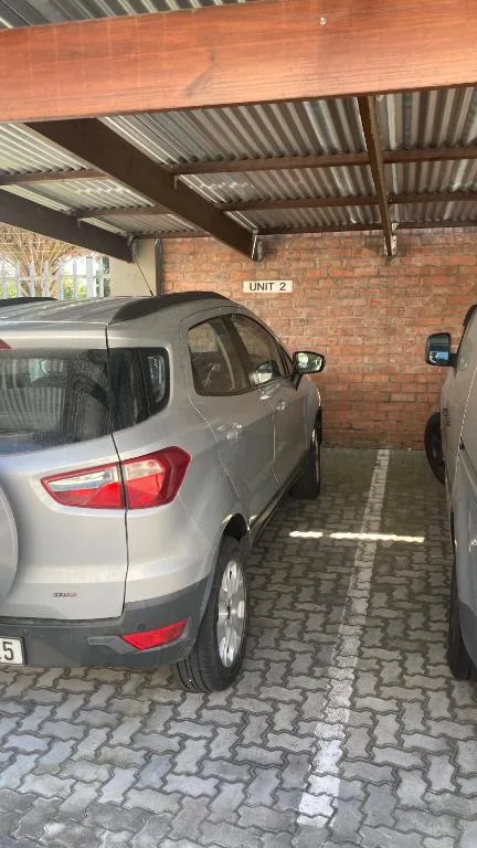 Covered carport with brick walls housing parked vehicles securely