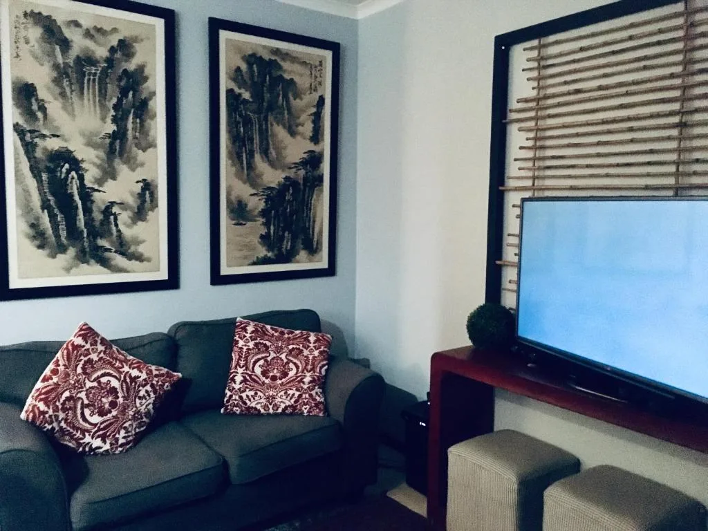 Comfortable lounge with dark sofa, decorative pillows, and wall art