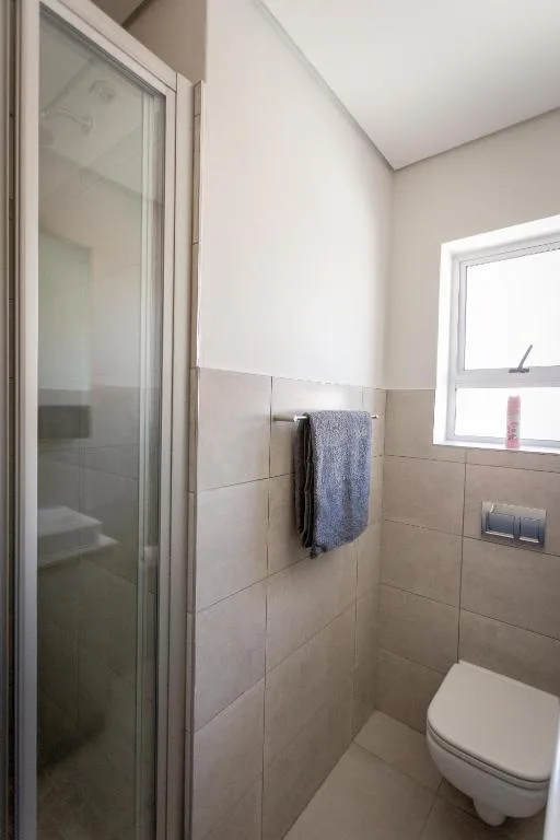 Modern bathroom with glass shower enclosure and wall-mounted toilet