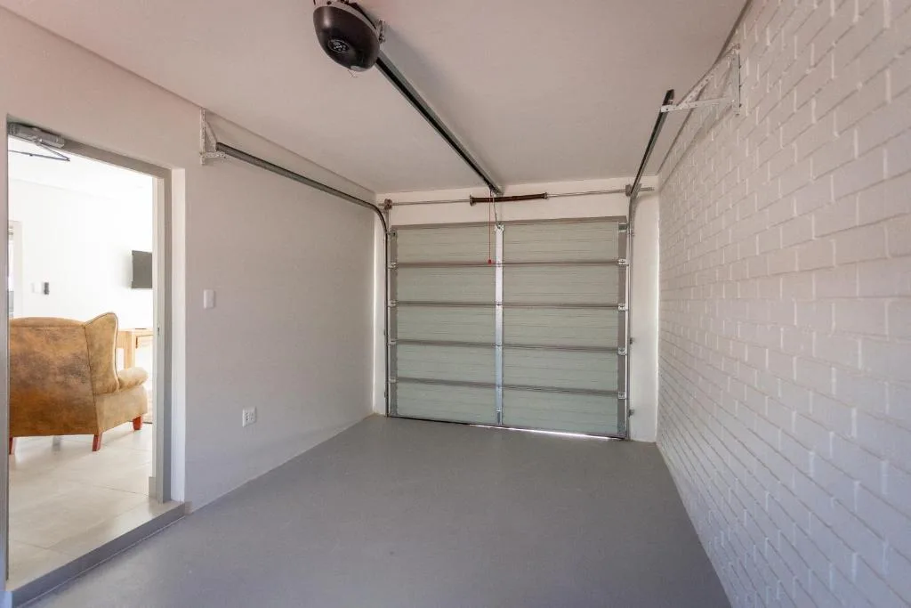 Modern garage interior with grey sectional door and brick wall
