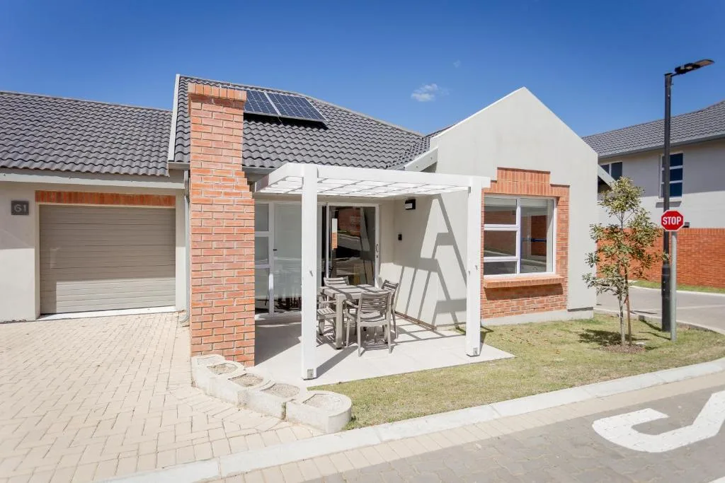 Modern townhouse with white pergola patio and brick chimney details