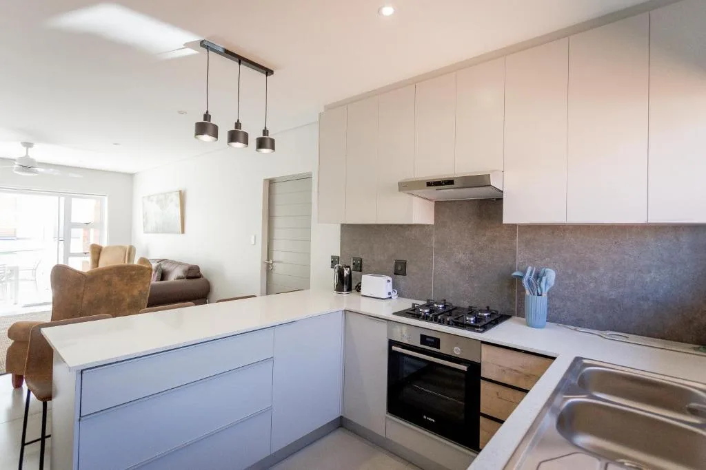 Modern kitchen with blue cabinetry, gas stove, and stainless steel sink