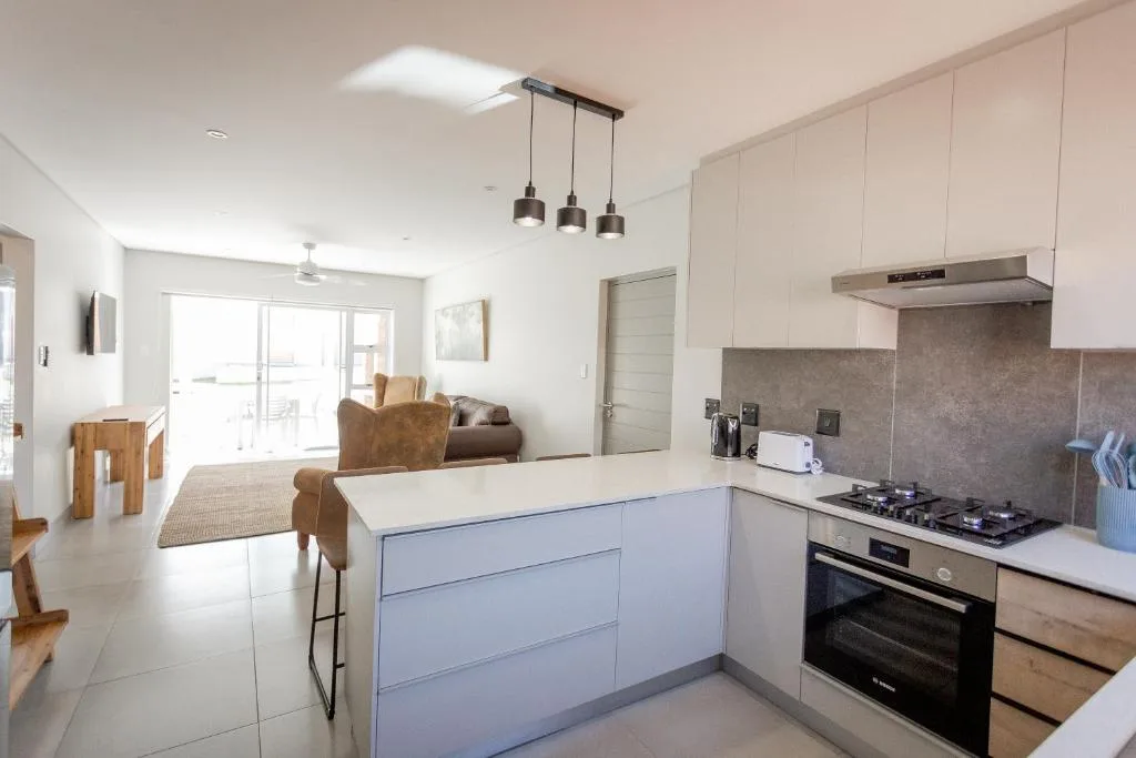 Modern kitchen with white cabinetry, gas cooktop, and pendant lighting overhead