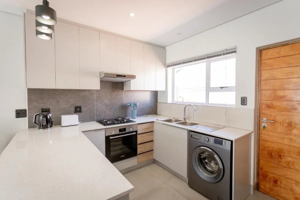 Modern kitchen with white cabinetry, stainless steel appliances, and granite countertops