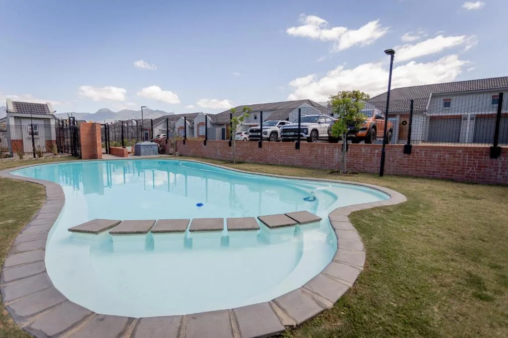 Turquoise swimming pool with lounge platforms and mountain views