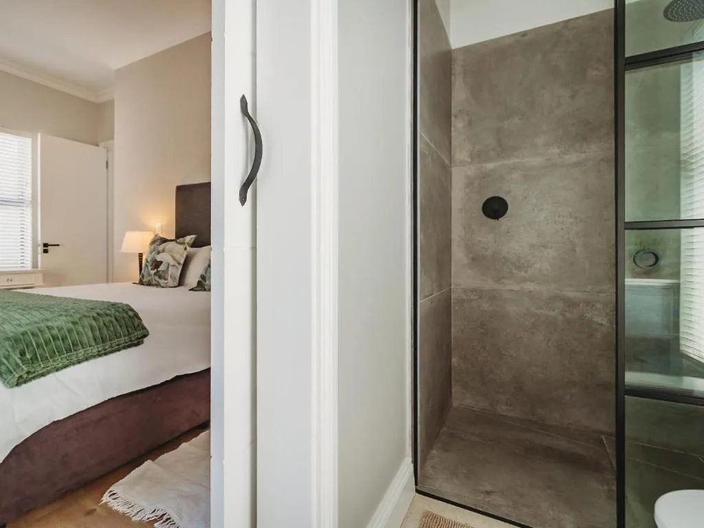 Modern ensuite shower with concrete tiles and glass partition door